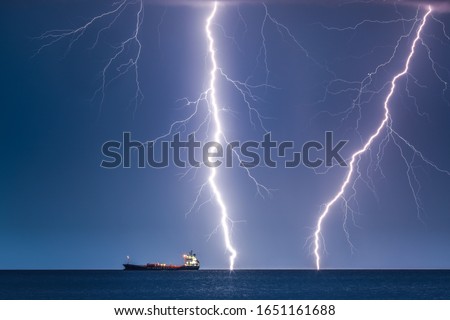 Night picture of thunderbolt hitting near ship
