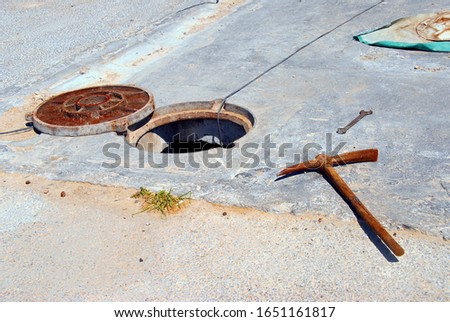 rusty pickaxe and open manhole