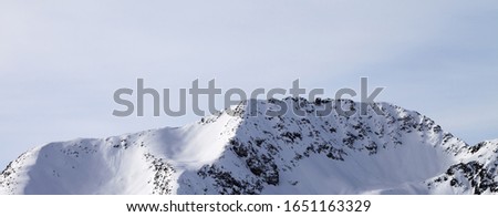 High winter mountains with snowy slopes and sunny cloudy sky at morning. Italian Alps. Livigno, region of Lombardy, Italy, Europe. Panoramic view.