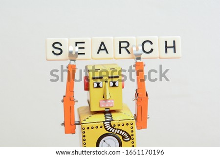 Search engine robot is looking for the best online website metaphor with toy robot on computer curuit board