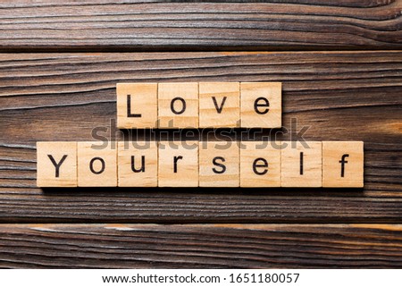 Love yourself word written on wood block. Love yourself text on wooden table for your desing, Top view concept.