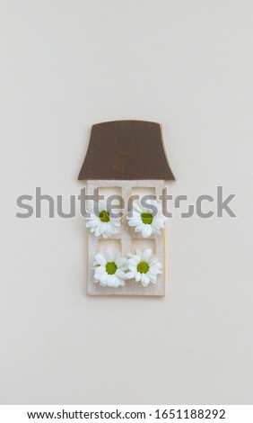 Wooden frame in shape of a house with daisy flowers, new home, mother's day, 8 March, spring, Easter postcard concept