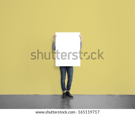 hipster holding blank placard on concrete floor