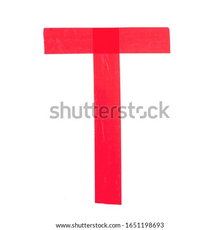 Letter "T" made from red construction adhesive tape. Isolated on white background