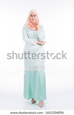 Beautiful female model in modern kurung and hijab, a modern lifestyle apparel for Muslim women isolated on white background. Beauty and hijab fashion concept. Full length portrait
