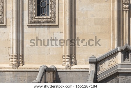 Details and architectural decorations of old buildings, stone walls and doors, arches, windows and doorways. On the streets in Georgia, public places. Texture background for design.