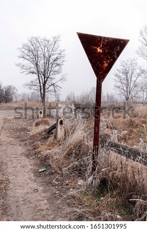 Yield sign on a winter road in the hungarian countryside.