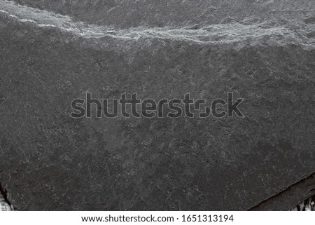 The background image of black stone rests on marble