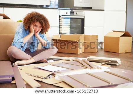 Frustrated Woman Putting Together Self Assembly Furniture Royalty-Free Stock Photo #165132710