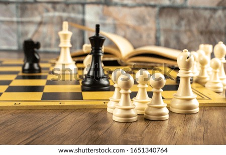White and black figures position on a chessboard