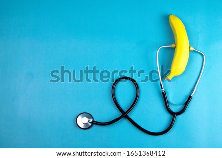 Yellow ripe banana with a stethoscope isolated on blue background. Healthcare And Medicine. Top views with clear space