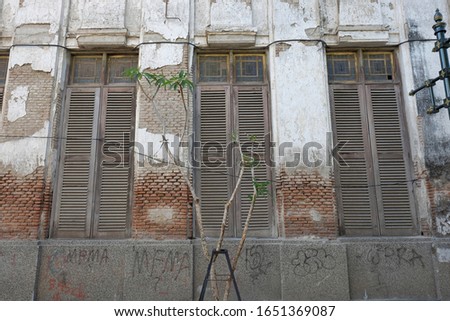 An old building with worn walls and large windows in the Old City area, Semarang.