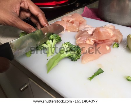 Cross contamination of food, raw and fresh vegetables are on the same chopping board Royalty-Free Stock Photo #1651404397