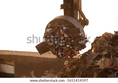 garbage isolated on the white background,Backhoe use electromagnets crane, magnet cranes are recycling metal, waste disposal industry,Greenhouse effect Royalty-Free Stock Photo #1651414597