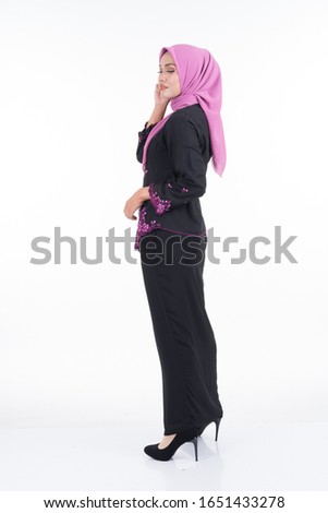 Beautiful female model in kebaya and hijab, a modern lifestyle apparel for Muslim women isolated on white background. Beauty and hijab fashion concept. Full length portrait