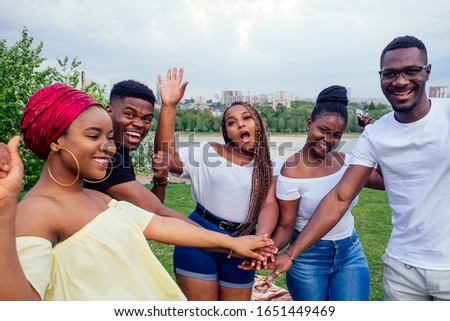 group of five smiling african-american men and women walking outside cloudy weather near the lake,exchange students in Russia Royalty-Free Stock Photo #1651449469