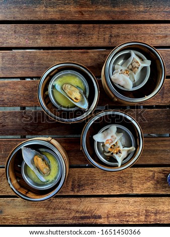 Dim sum stock photo. Cantonese style of steamed dumpling in small, almost bite-sized portions wit variety of fillings. Chinese cuisine restaurant experience. Best for menu, cafe or blog decoration. 