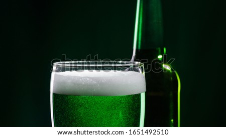 Glass of green beer and bottle. St. Patrick's Day concept. Royalty-Free Stock Photo #1651492510