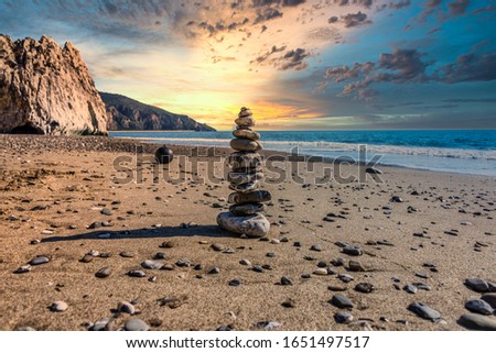 Meditative Stone Stack on a Mediterranean Beach in Southern Italy at Sunset Royalty-Free Stock Photo #1651497517