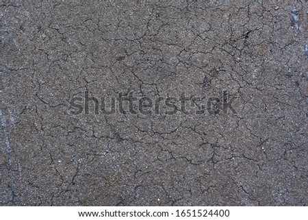 Background texture of old, broken asphalt.  Abrasions and cracks on the surface Royalty-Free Stock Photo #1651524400