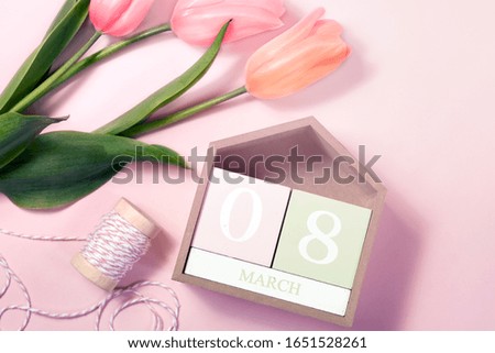 8 March Happy Women's Day concept. With wooden block calendar and pink tulips on pastel background