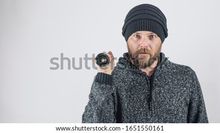 A Bearded Man Holds A Diode Flashlight In His Hand On A Blank White Background. Place For Advertising. Copy Space. The Highest Quality Photograph