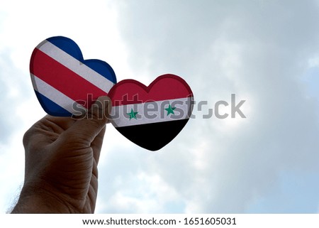 Hand holds a heart Shape Costa Rica and Syria flag, love between two countries