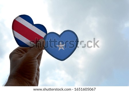 Hand holds a heart Shape Costa Rica and Somalia flag, love between two countries