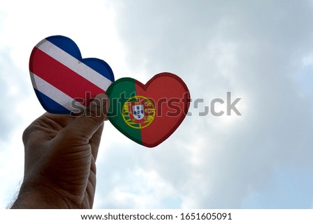 Hand holds a heart Shape Costa Rica and Portugal flag, love between two countries