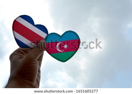 Hand holds a heart Shape Costa Rica and Azerbaijan flag, love between two countries