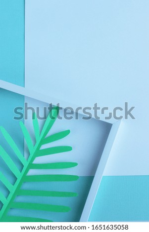 the green leaves of the palm tree are neatly arranged in a white paper frame. exotic background. green paper leaves