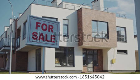 View of beautiful modern new house mortgage loan with a white sign for sale real estate in the city. Housing property concept.