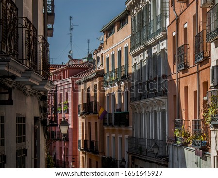 Exterior view of beautiful historical buildings in Central Madrid, Spain, Europe. Colorful street scene in the Lavapiés, Embajadores neighborhood of the Spanish capital. Royalty-Free Stock Photo #1651645927