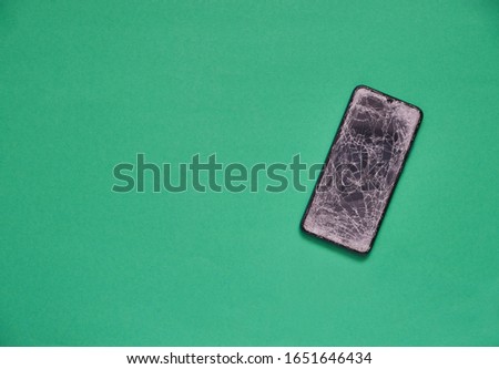 Broken phone on green background