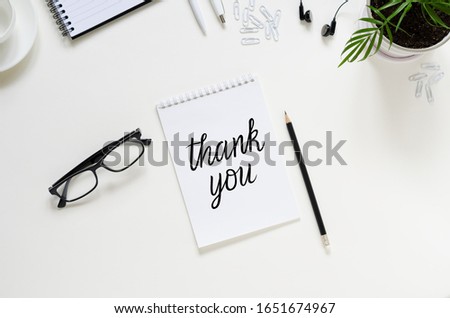 Workspace with pen, paper, coffee cup, glasses, green plants and office supplies. Top view flat lay overhead. Employee appreciation day concept Royalty-Free Stock Photo #1651674967