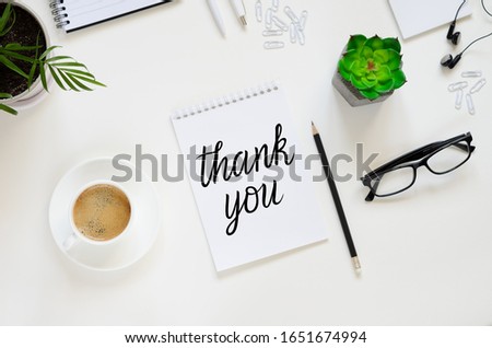 Workspace with pen, paper, coffee cup, glasses, green plants and office supplies. Top view flat lay overhead. Employee appreciation day concept Royalty-Free Stock Photo #1651674994
