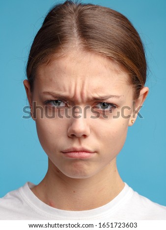 emotional portrait of a young attractive girl. Studio shooting, blue background