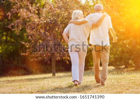 Two seniors go for a walk in nature in summer Royalty-Free Stock Photo #1651741390