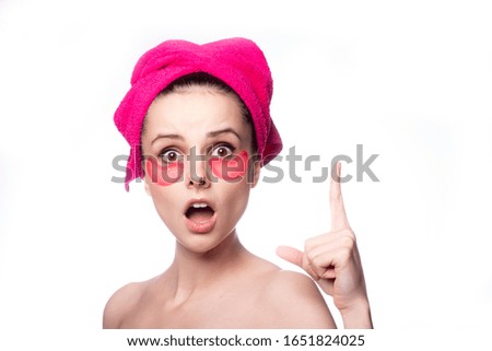 young woman after a shower in a pink towel and patches