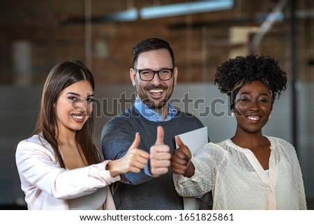 Portrait of a group of businesspeople showing thumbs up in an office. Business people Giving Thumbs up. Group of business people holding up their thumbs. Your hard work hasn't gone unnoticed