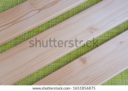 Light wooden DIY boards on green background