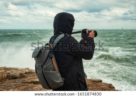 Photographer taking picture of a stormy sea