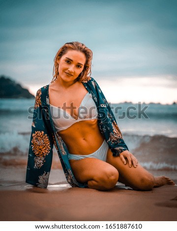 Lifestyle, young caucasian woman on the beach with white bikini and a blue flower shirt