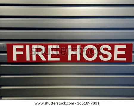 Warning sign indicating fire hose.