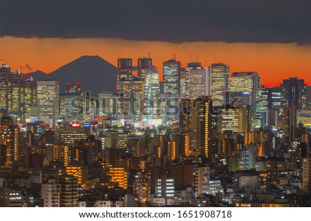 Aerial view of Tokyo Downtown and Fuji mountain. Financial district and business centers in smart urban city in Asia. Skyscraper and high-rise buildings at night. Japan.