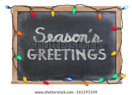 Season's Greetings hand drawn with white chalk on a black chalkboard surrounded with colorful lights isolated on white