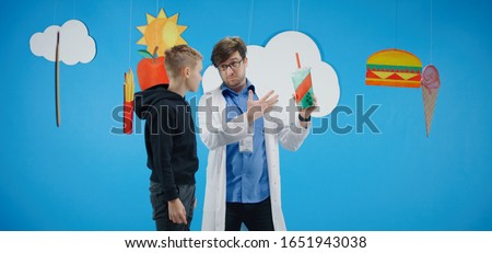 Medium shot of a doctor explaining to a boy about healthy and unhealthy food