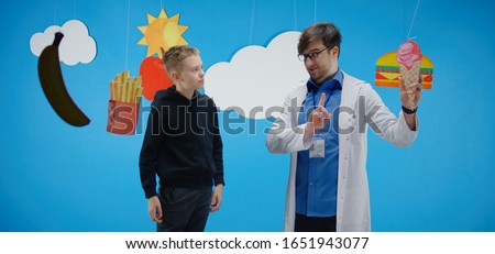 Medium shot of a doctor explaining to a boy about healthy and unhealthy food