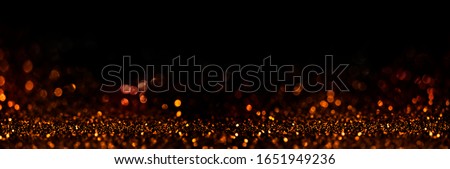 Abstract blur golden glitter on black background. Card for new year, christmas and wedding celebration. Party bokeh sparkle confetti textured layout. Classy elegant design.