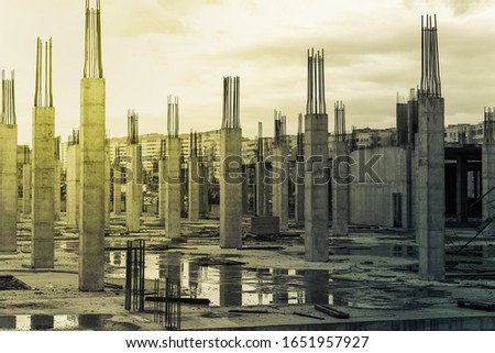 Building of a new appartment house. Construction site with reinforced concrete columns. Tinted in green and yellow color, sepia effect. Stock photo
